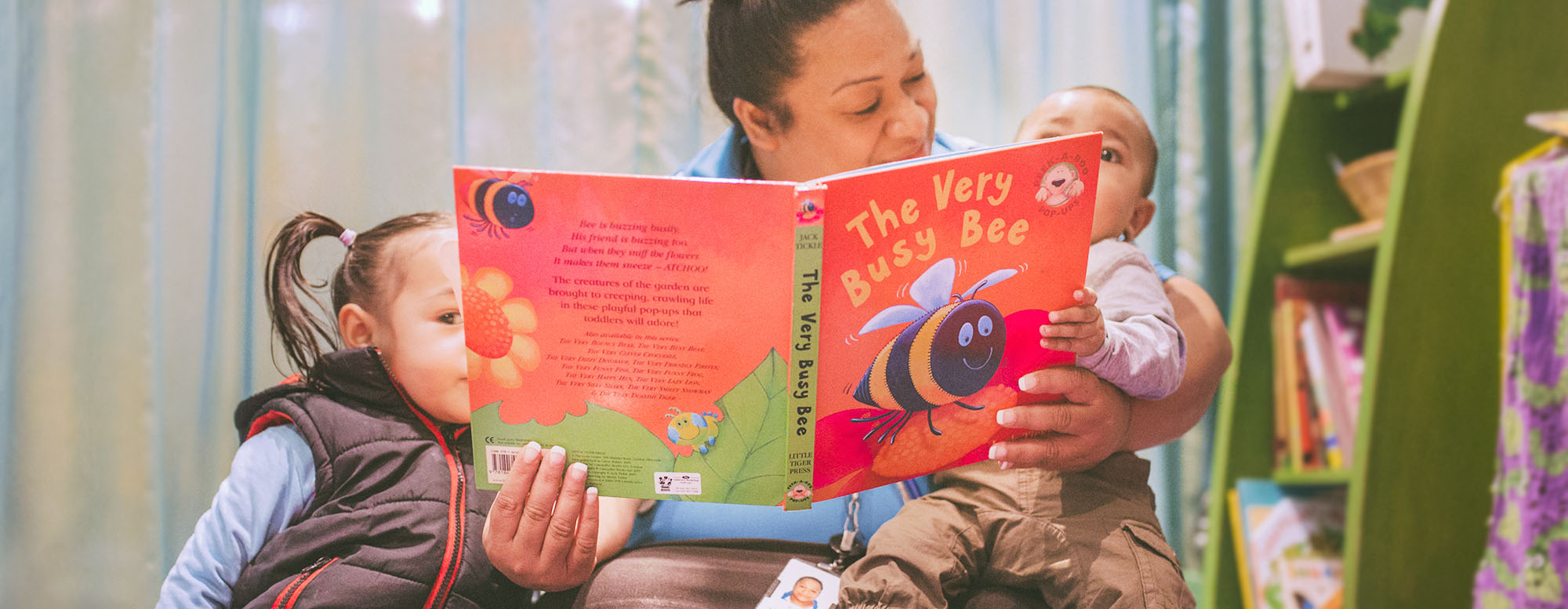 A woman reads a book to two children