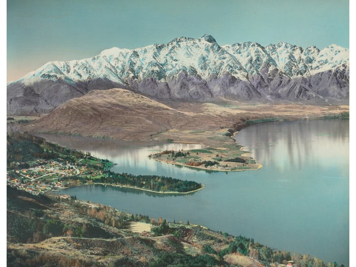 Queenstown. From the album: Hand coloured views of New Zealand; 1940 s; Whites Aviation, 1945-1960, Queenstown, by Whites Aviation. Purchased 1999 with New Zealand Lottery Grants Board funds. Te Papa (O.033079) An old photograph of Queenstown that has been colourised.