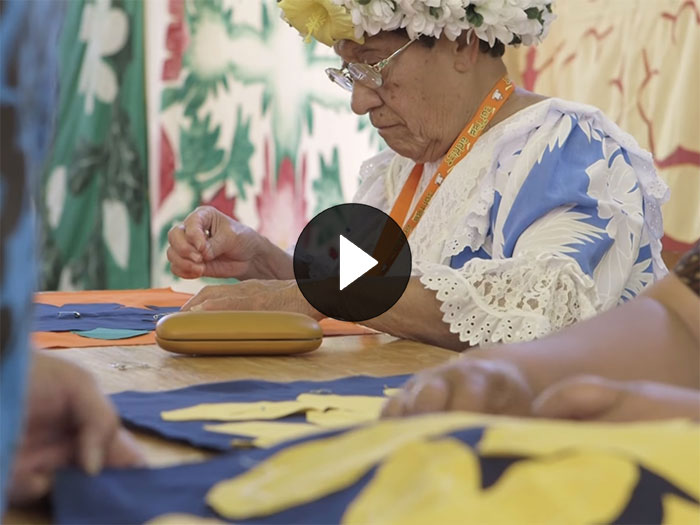 A lady sews a quilted (a Tīvaevae)