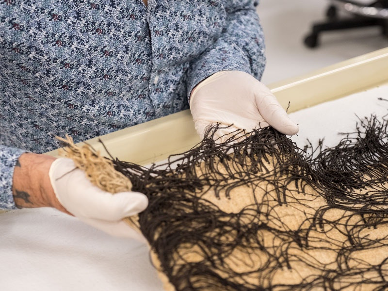 Caring for a korowai, 2018. Photo by Rachael Hockridge. Te Papa Caring for a korowai