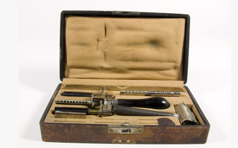 Wooden shaving box lined with yellow material with shaving implements