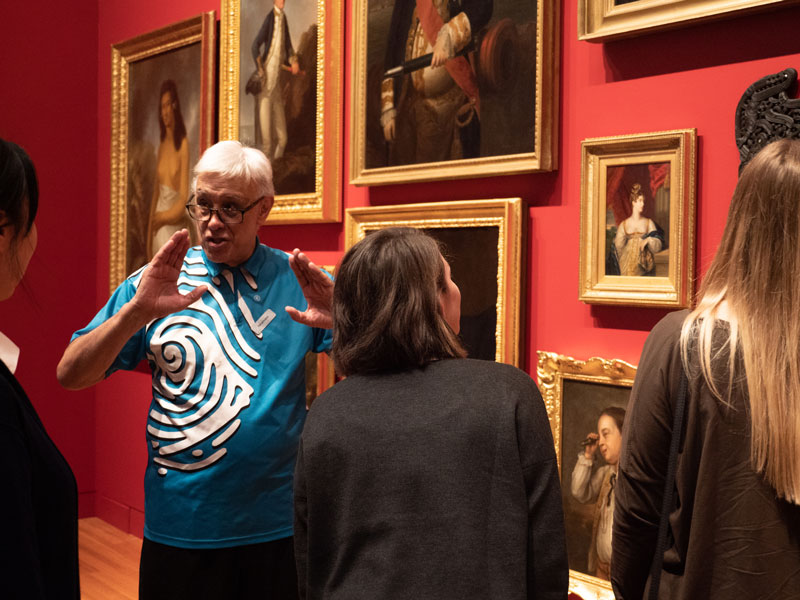 A guided tour happening in front of lots of paintings