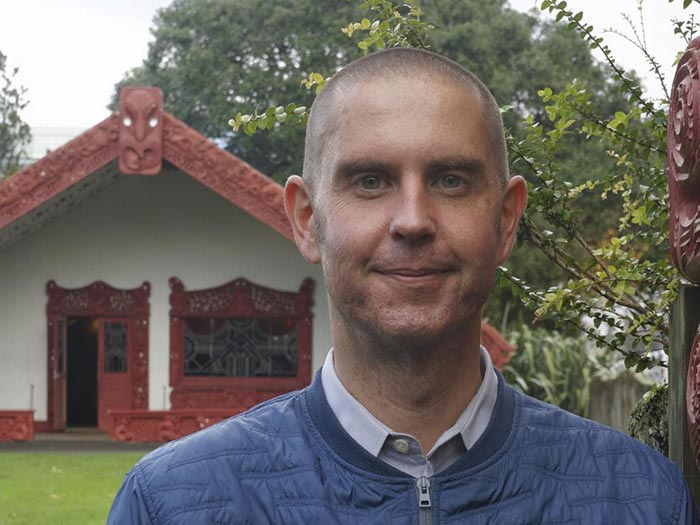 Damian Skinner in front of meeting house