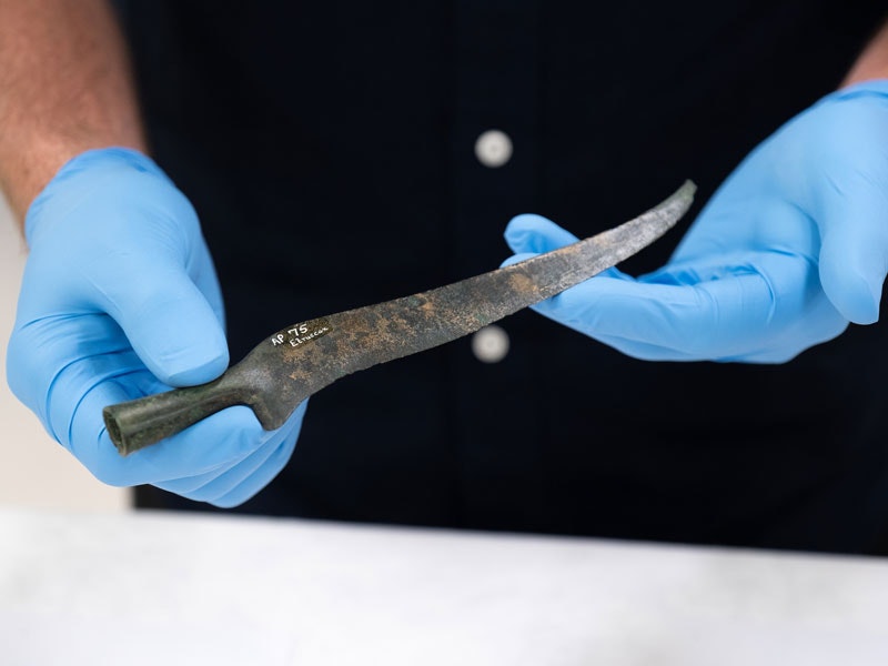 Copper knife, Italy, maker unknown. CC BY-NC-ND 4.0 (AP000075) Photo by Rachael Hockridge. Te Papa Gloved hands hold a knife