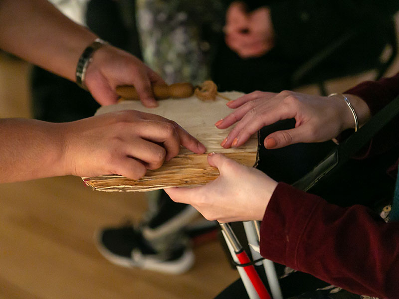 Visitors handling a tapa cloth sample at a 2018 Toi Art Sensory Tour