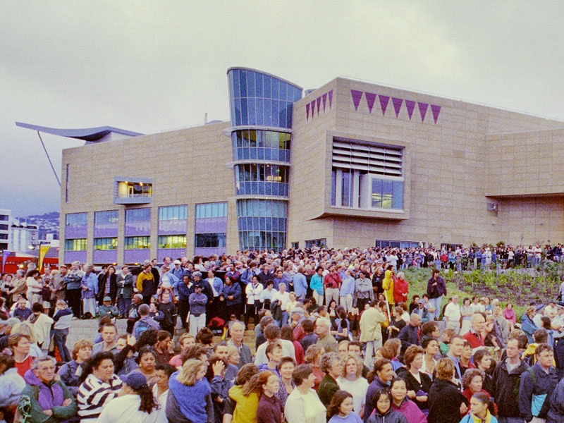 Watching the waka come into the harbour on Te Papa's opening day, 1998. Te Papa People crowded round Te Papa on opening day