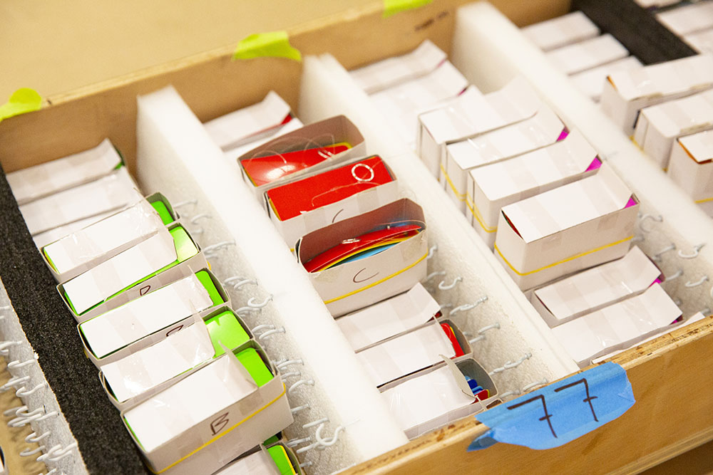 Close-up of a box containing lots of small boxes, each contains a strand of Finale: Bouquet which will eventually hang from the ceiling