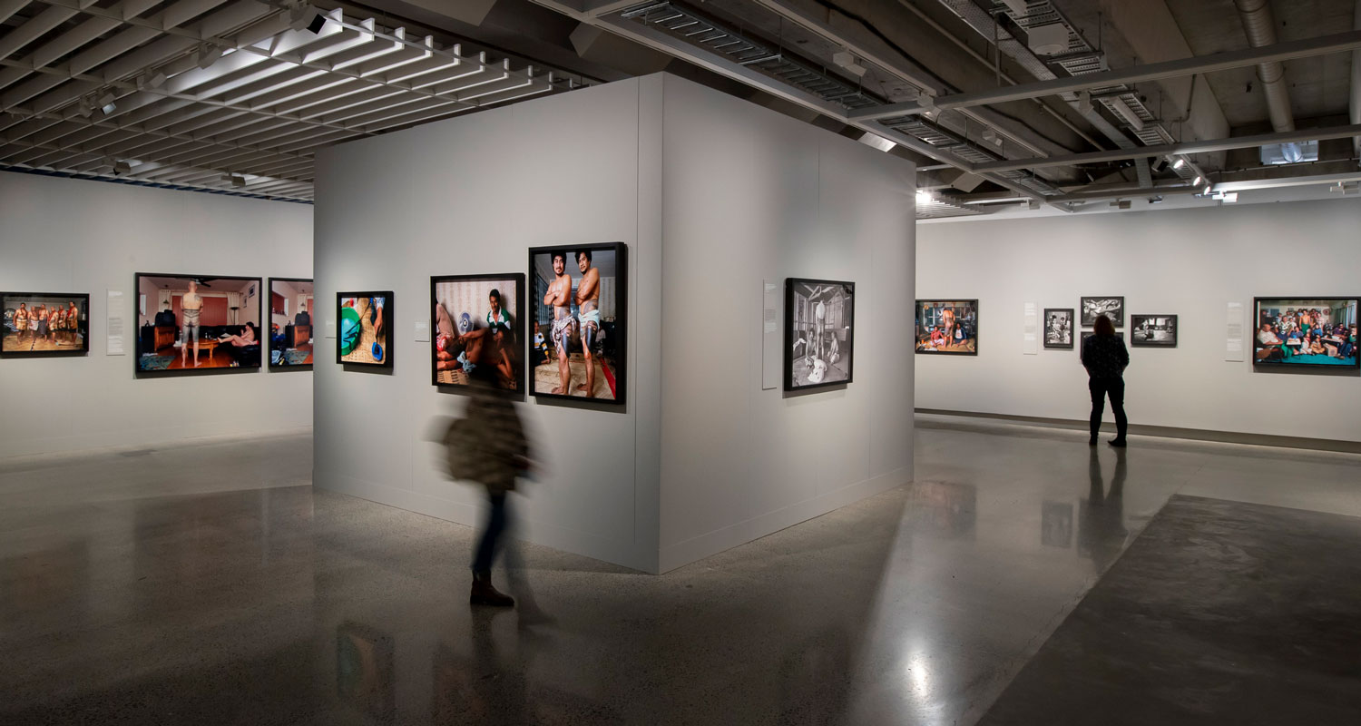 Visitors look at photos on gallery walls