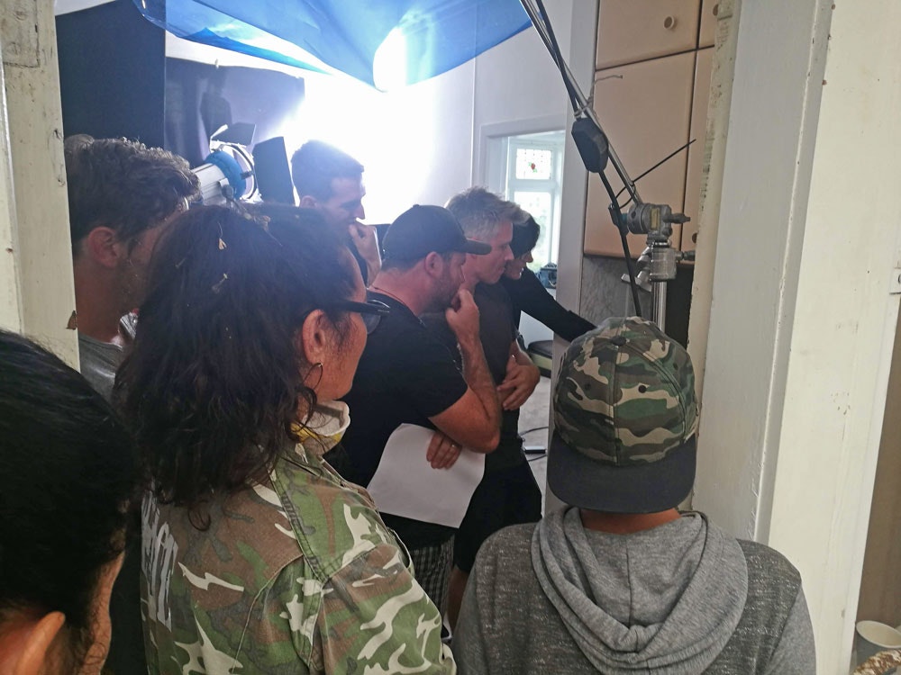 Making the new Quake House video, 2019. Te Papa People gather round a computer screen