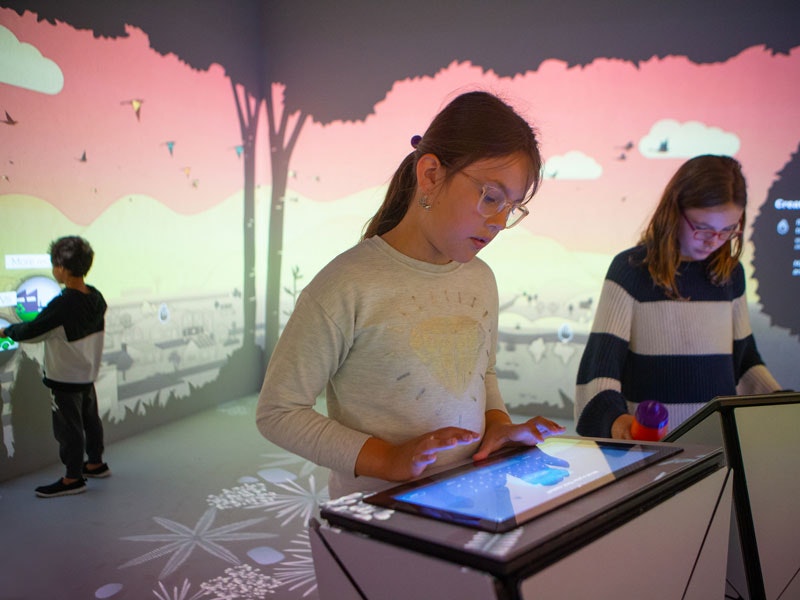 Kids in the Climate Converter in Te Taiao, 2019. Te Papa (139210) Kids using technology surrounded my screens with scenes of nature