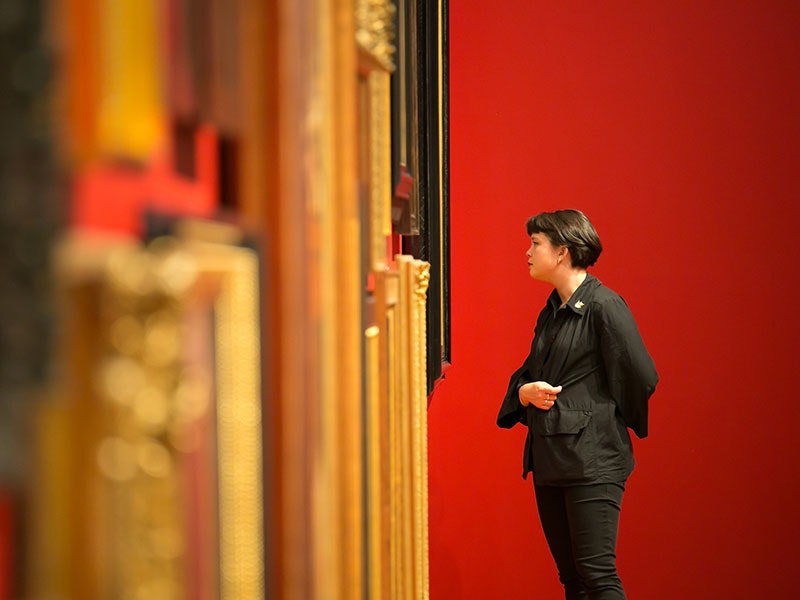 A Toi Art visitor examines the portrait wall in Tūrangawaewae: Art and New Zealand, 2018. Photo by Jo Moore. Te Papa (103277) toi-art-800x600.jpg