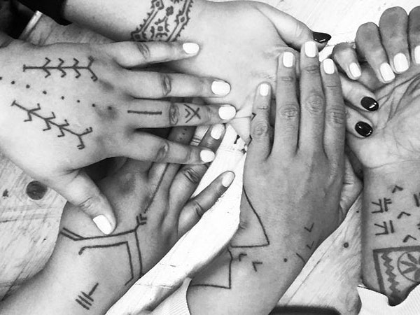 Lunch with Melanesian women, 2018. Photo by and courtesy of Julia Mage’au Gray Black and white photo of five tattooed hands together