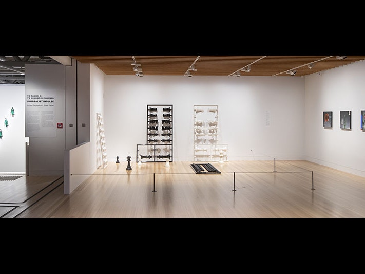 General view of the Surrealist Impulse exhibition, 2021. Photo by Maarten Holl. Te Papa General view of the Surrealist Impulse exhibition. One work, of four men, hangs in a stairwell, one sculpture of a chess set stands on the floor leaning against the wall, and three square paintings also hang on a wall