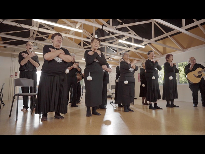 Video still from Taikura Kapa Haka 2021. Te Papa People in a large room performing a dance with actions