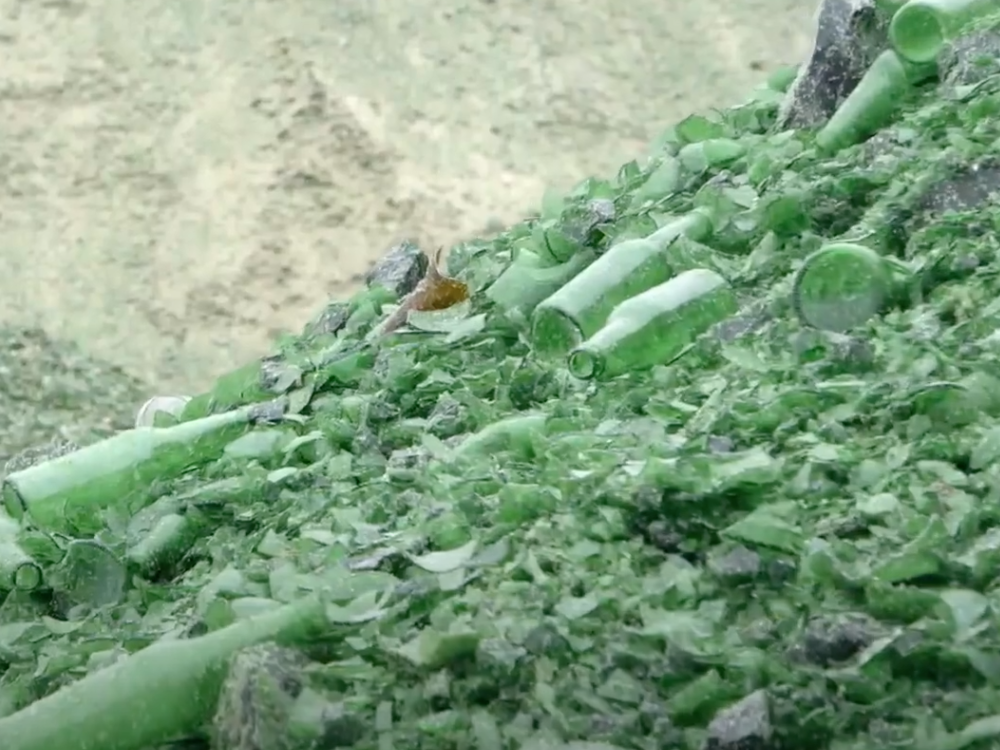 Video still from Glass recycling, nationwide. Te Papa A mountain of green glass from broken bottles