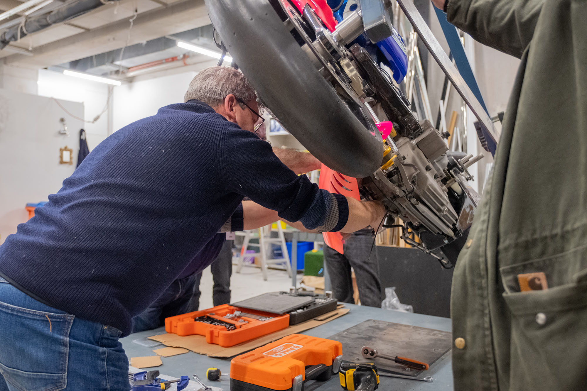 Craig removes a bright pink piece from the underside of the Britten Bike