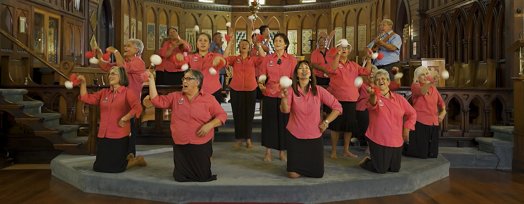 A lot of older people standing and singing on a stage