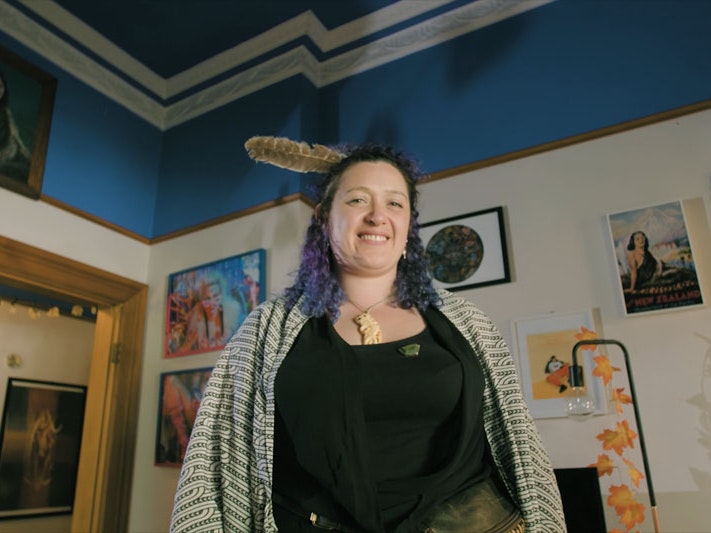 Still from Ngā Taonga Tuku Iho #2: You Are It, So Live It, 2022, by Pikihuia Haenga and Elise Lanigan. Image courtesy of Kahu Kutia A woman stands looking directly into the camera. The camera is looking up at her