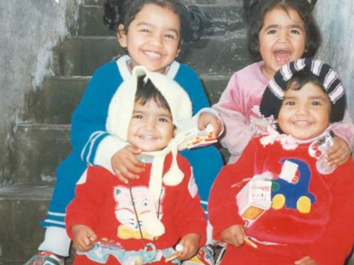 Mehwish (in blue) and three of her siblings. Photo courtesy of Mehwish Mughal Photo of four young children posing for a photo