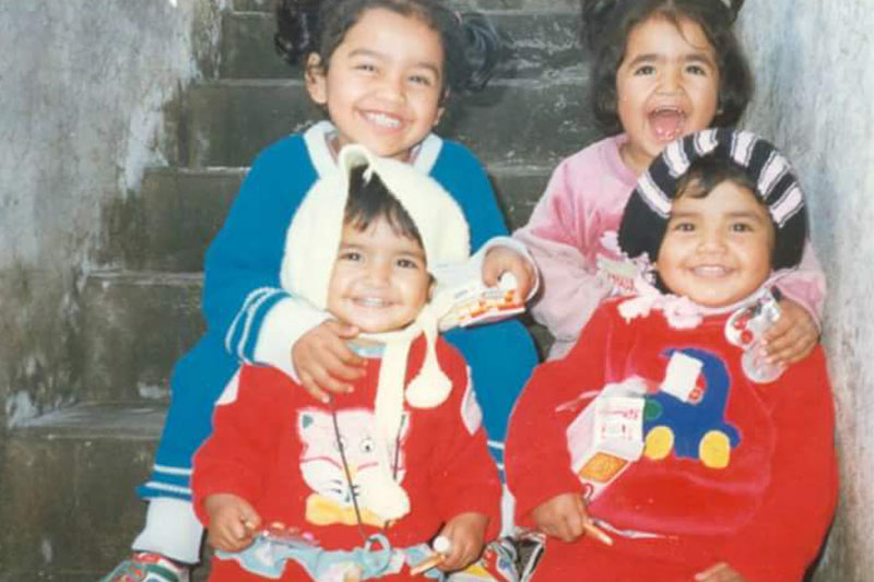 Photo of four young children posing for a photo