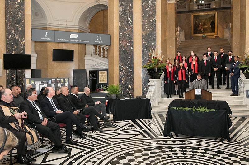 A group of people on a set of steps in a room with other people