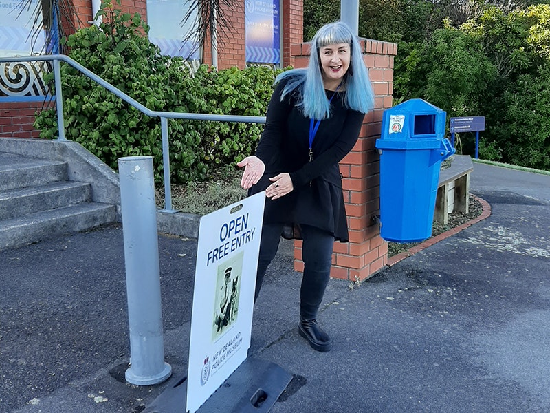 20200517_215616000_ios.jpg A woman stands in front of a building pointing to the sign outside of a museum