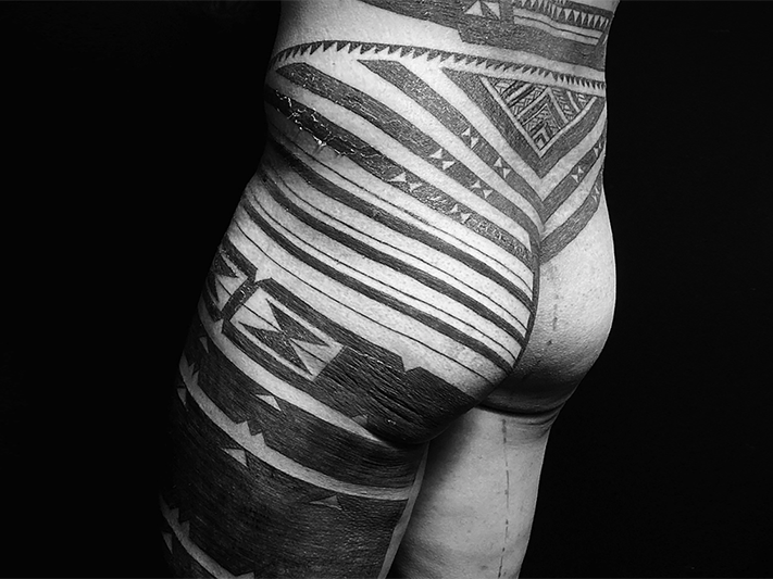 Tātatau faka-Tonga made by Terje Koloamatangi. Photo courtesy of Terje Koloamatangi Black and white photo of the back and leg of a tattooed man