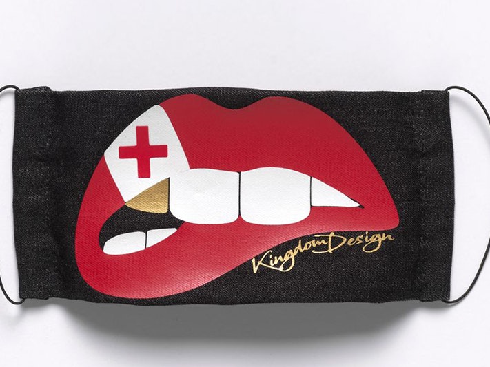 Czarina Wilson, Face mask Tonga Flag Nifo Gold (Limited Edition) Prototype, May 2020; Glen Innes. Purchased 2020. Te Papa (FE013563) a black facemask with the image of a mouth with red lips, white teeth and a single gold tooth
