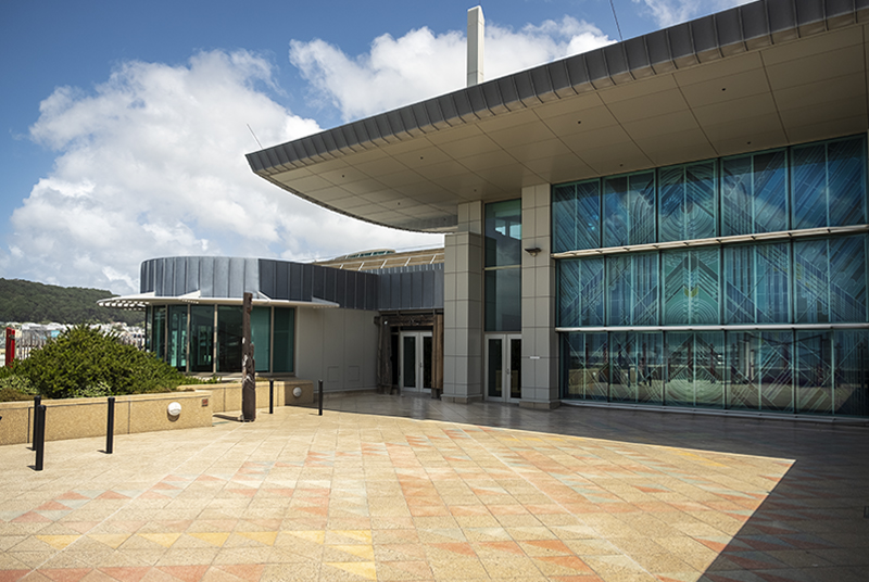 A large patio space with a big glass door on the right-hand side of the building surrounding it. There are two smaller doors on the left.