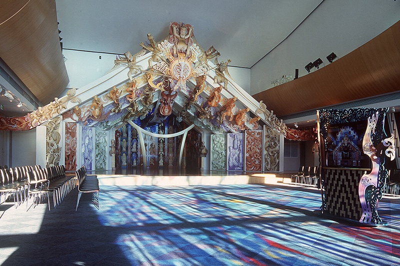 A colourful stage within a room with sunlight through coloured windows bathing the room in shades of blue and purple