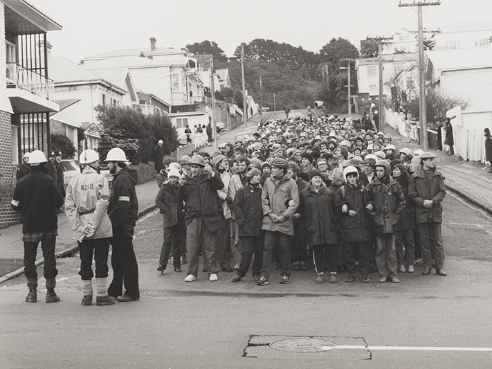 Ans Westra, Anti Springbok tour demonstration, August 1981, Wellington. Purchased 1993 with New Zealand Lottery Grants Board funds. Te Papa (O.012082) People standing in a group ready for a protest. There are police standing to the left of them.