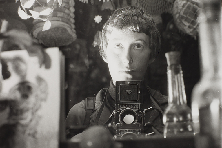 A woman with a camera is taking a self portrait in a mirror.