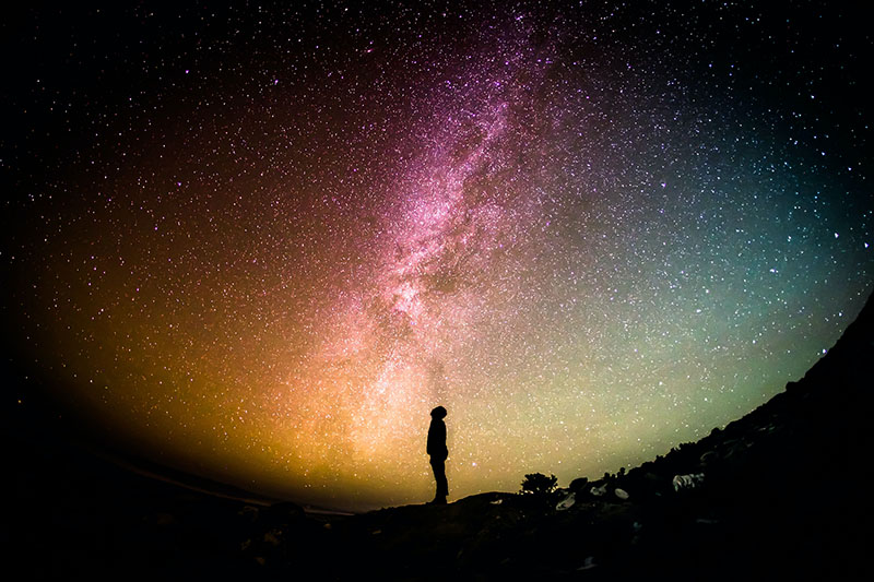 A man looking up towards the starry sky