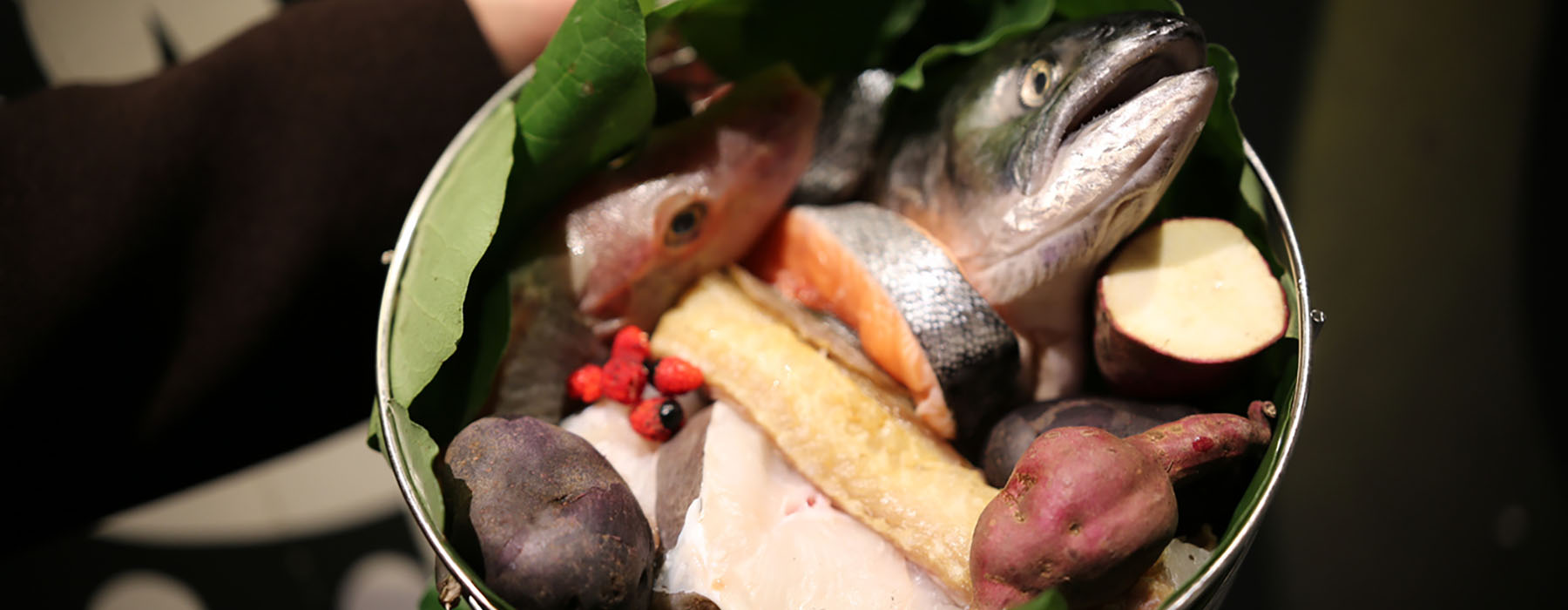 A bucket full of kūmara, salmon, fish, and other vegetables