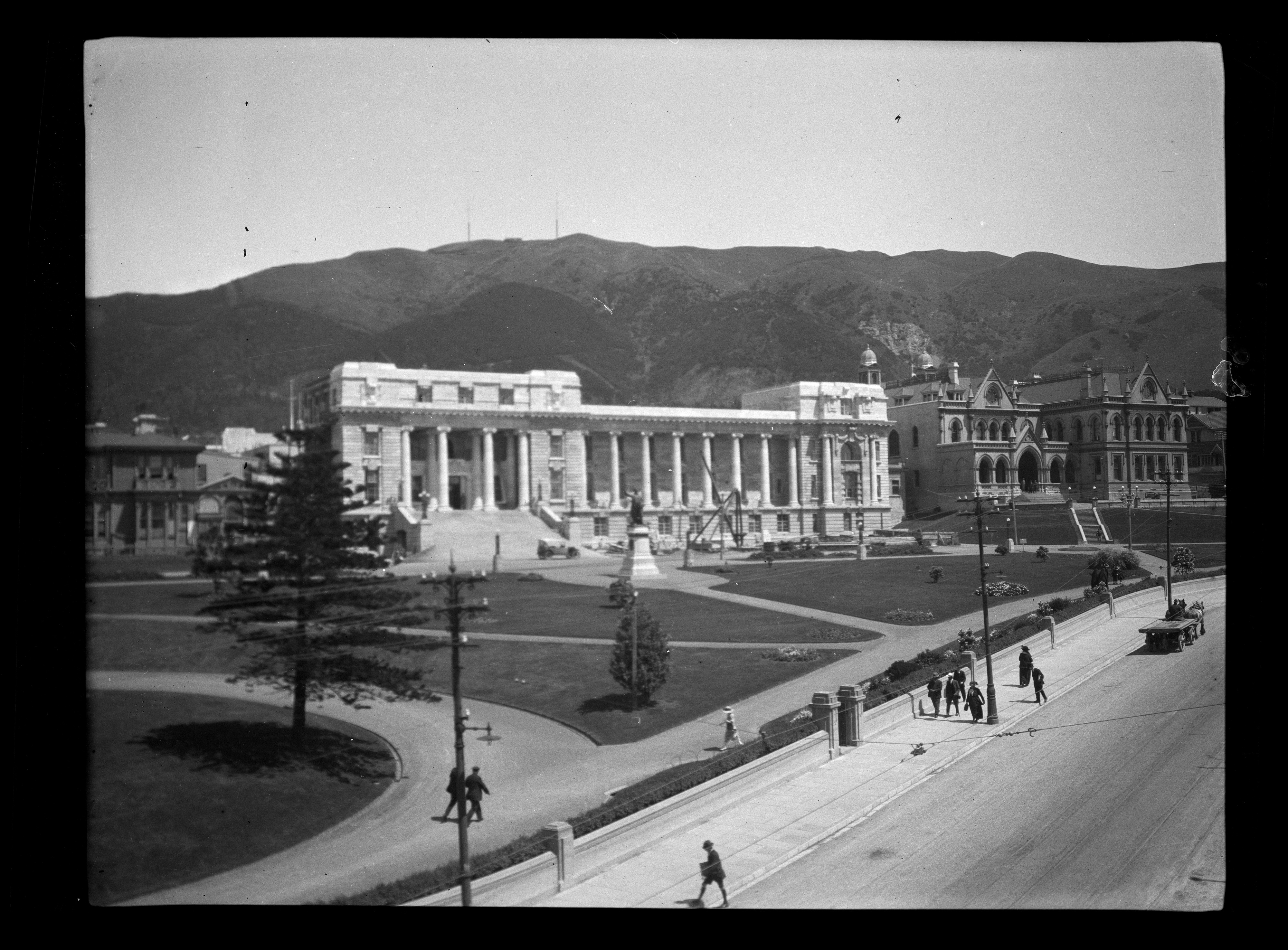 Black and white photo of a large stone building with manicured lawns in the foreground