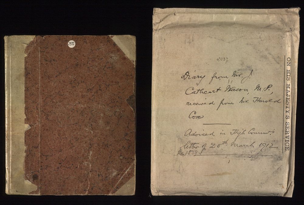 An old book with a paper bag next to it with handwriting covering it.