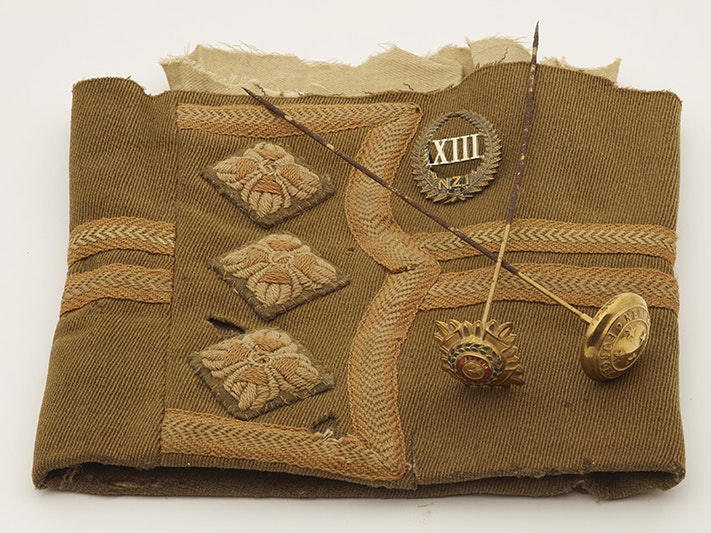 Uniform sleeve (partial), cap badge and hat pins, 1914-1918, New Zealand, maker unknown. Gift of Marianne Abraham, 2010. CC BY-NC-ND licence. Te Papa (GH016805 (sleeve), GH016802 (badge), GH016800 (hat pin left), GH016802 (hatpin right)) A part of an army uniform sleeve with pins on it