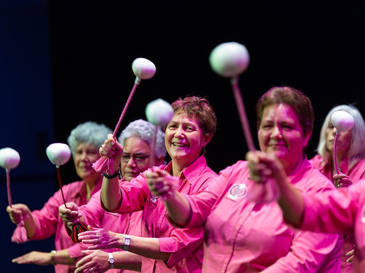 Matariki Festival 2018. Auckland Anglican Māori Club at Taikura Kapa Haka event, 2018. Photograph by Jo Moore. Te Papa (108183) Women all wearing black skirts and pink shirts swinging poi in unison (white balls on cord).
