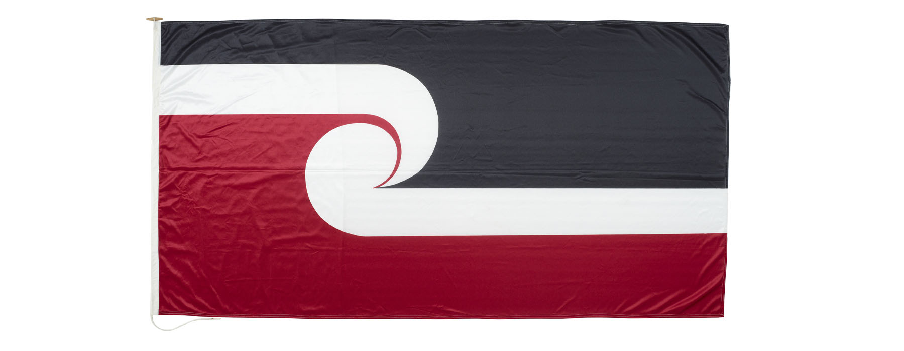 Tino rangatiratanga flag: top third is black, bottom third is red, middle third, in the shop of two koru, is white