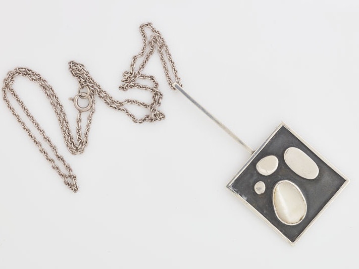 Tanya Ashken, Pendant and chain, 1963, sterling silver, mother of pearl. Te Papa (2016-0013-1) Square pendant with mother of pearl ornaments on it