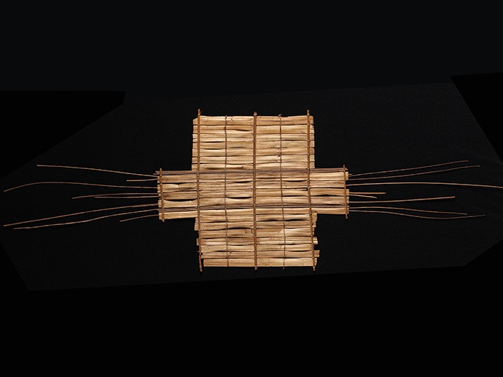 ma_i007420.jpg A rectangle woven from flax and wood with long sticks pointing out the sides like whiskers.