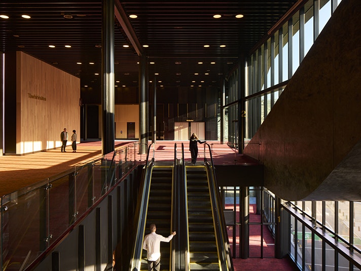 _e2a5168-cr3_d.jpg Inside a convention centre with escalators and people walking around.
