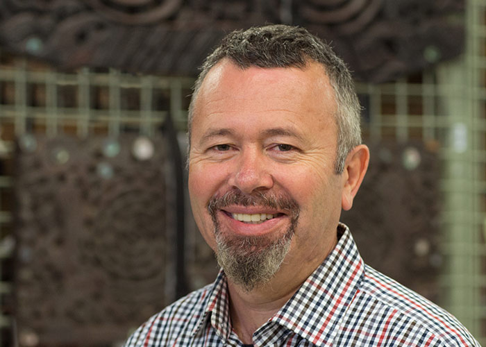 Head and shoulders of a man with a goatee beard. He is smiling at the camera.