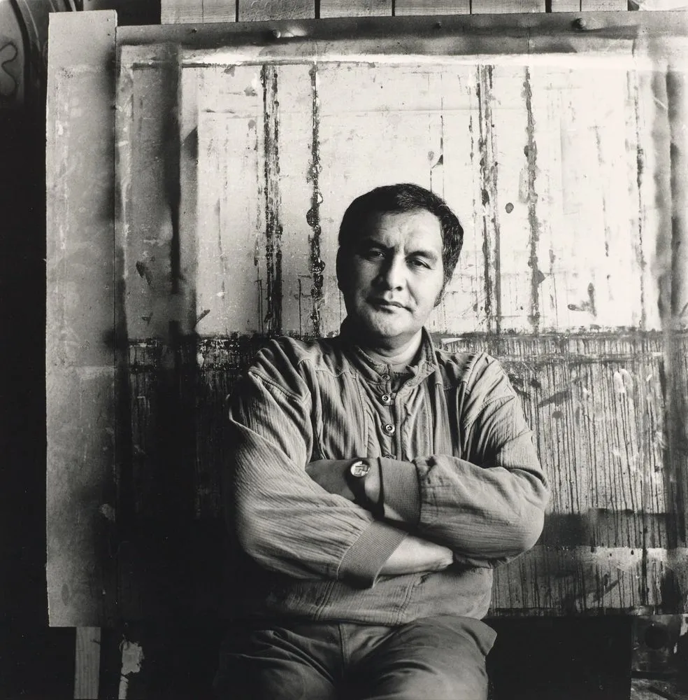 A black and white photo of a man looking at the camera.