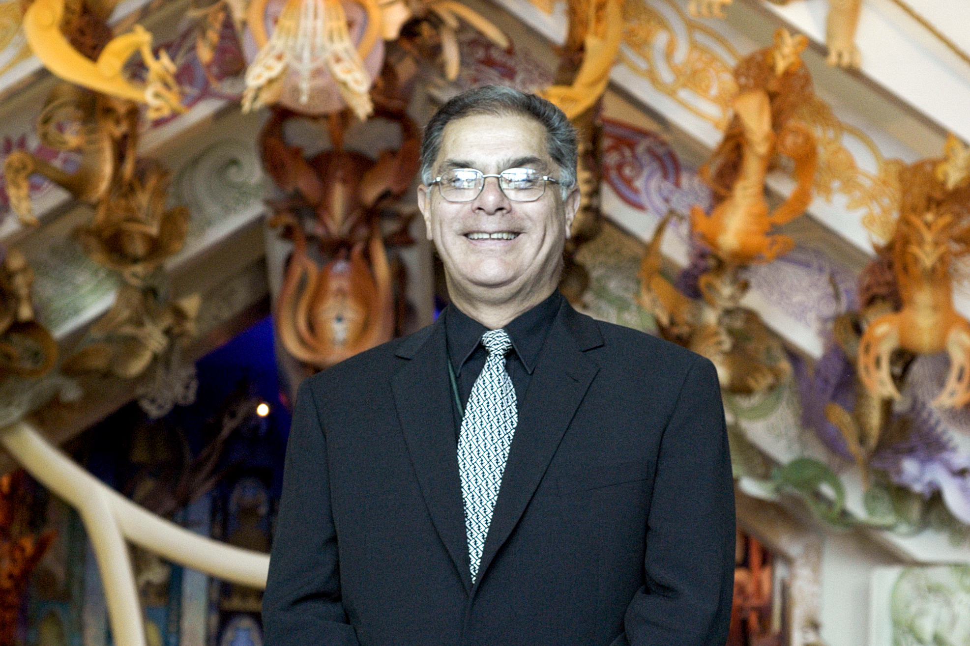 A head and shoulders photo of a man in a suit smiling at the camera.