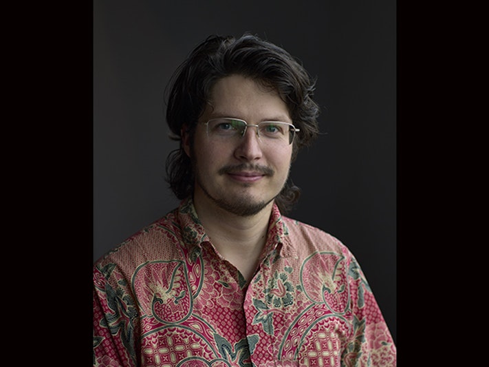Kerry Walton. Photo by Yoan Jolly. Te Papa Head and shoulders photo of a man smiling at the camera