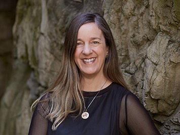 Rebecca Rice. Photo by Yoan Jolly. Te Papa Head and shoulders of a woman with long hair smiling at the camera