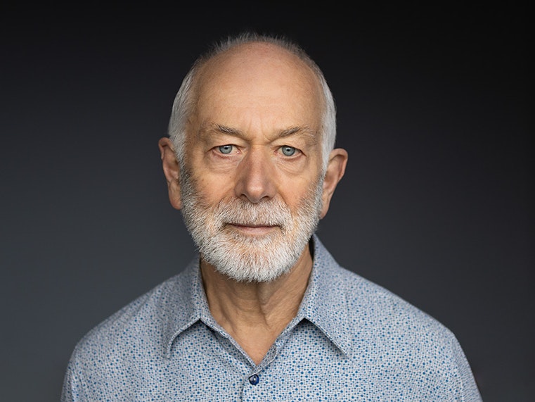 Athol McCredie. Photo by Yoan Jolly. Te Papa Head and shoulders of a man with a white beard and blue eyes who is looking at the camera.