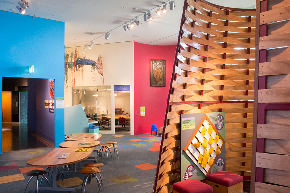 A space in a building with tables and things on the walls.