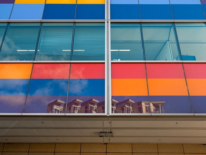Exterior view of Te Papa, 2019. Photo by Daniel Crichton-Rouse. Te Papa (145828) A wall of brightly coloured windows with a reflection of another building on the bottom windsows.